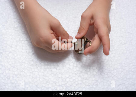Mano che regge un cuore a forma di lucchetto e chiave su sfondo bianco Foto Stock