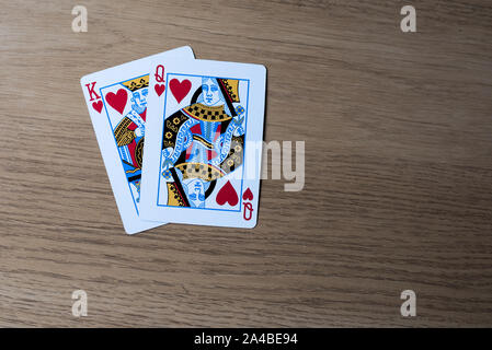Re e Queen cuori da un pacchetto di carte su un tavolo di legno Foto Stock