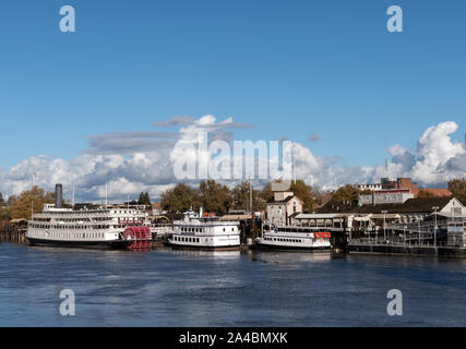 Il Delta King pedalo' sternwheel steamboat e altri riverboats, ancorata al di sotto della vecchia sezione di Sacramento del centro di Sacramento, California la città capitale della Foto Stock