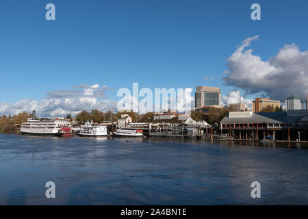 Il Delta King pedalo' sternwheel steamboat e altri riverboats, ancorata al di sotto della vecchia sezione di Sacramento del centro di Sacramento, California la città capitale della Foto Stock