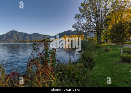 Un bellissimo lago con autunno piante colorate con una montagna in background. Foto Stock