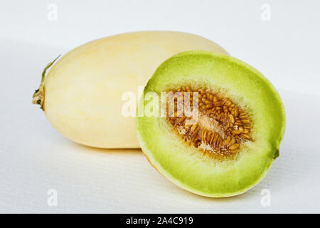 Metà di melone giallo melone frutto su sfondo bianco. tagliare maturo dolce melata di melone verde Foto Stock