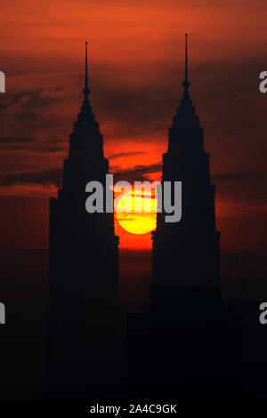 Kuala Lumpur, Malesia. Xiv oct, 2019. Il sole sorge dalla direzione tra le Petronas Twin Towers di Kuala Lumpur in Malesia, il 14 ottobre 2019. Credito: Chong Voon Chung/Xinhua/Alamy Live News Foto Stock