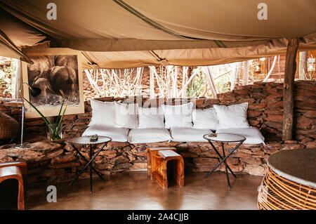 JUN 20, 2011 Tanzania - African Luxury Safari Lodge stanza vivente con il bianco cusions e Boho mobili tribali nella foresta di savana del Serengeti Grumeti wi Foto Stock