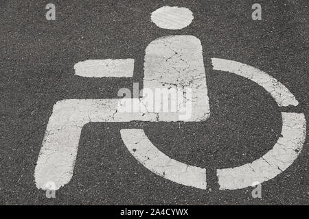 Close-up della segnaletica stradale su asfalto: posizione di parcheggio per disabili Foto Stock
