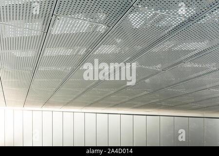 Vista diagonale di metall griglie e fori tondi in metallo superficie di soffitto, pannelli perforati Foto Stock