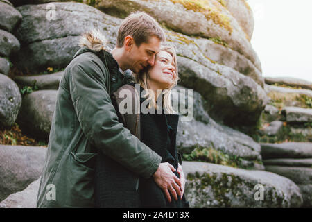 Felice giovane famiglia incinta vestito in stile casual camminare insieme sulla natura park nella stagione fredda, famiglia advenure travel Foto Stock