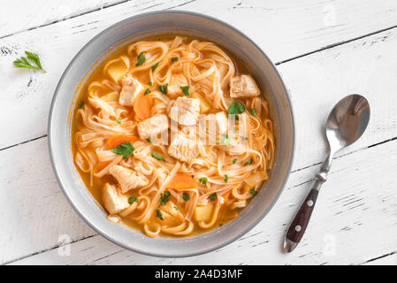 Zuppa di noodle al pollo con le verdure nella ciotola, vista dall'alto, copia dello spazio. In casa di pollo o zuppa di Turchia. Foto Stock