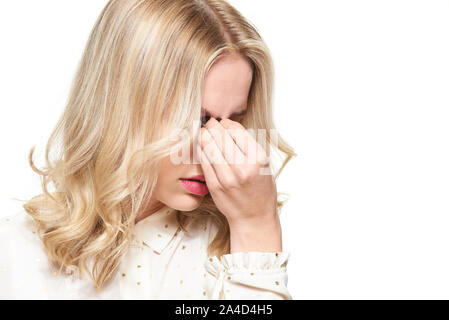 Sottolineato esaurito giovane femmina avente una forte tensione mal di testa. Sensazione di pressione e di stress. Premuto donna con testa in mani su sfondo bianco. Foto Stock