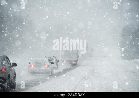 Egli auto è la guida su una strada in inverno in una bufera di neve Foto Stock