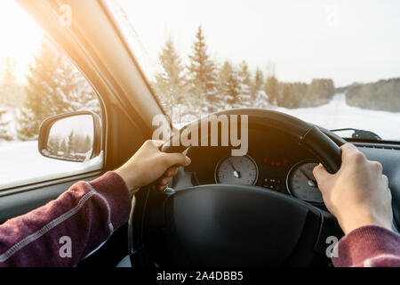 Un uomo aziona un auto su una strada di inverno Foto Stock