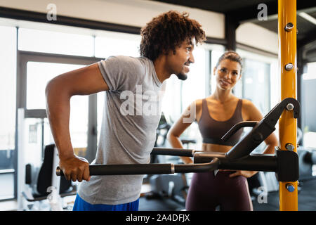 Istruttore di Fitness esercizio con client presso la palestra. Foto Stock