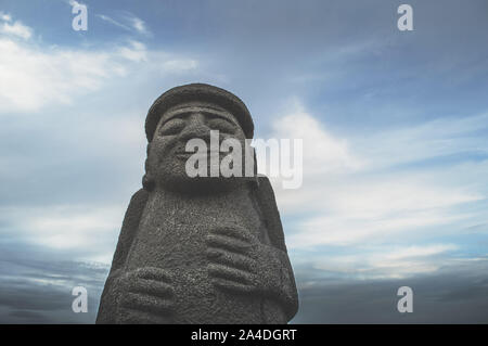 Jeju Island, Corea del Sud, settembre 05, 2019: vista dal basso sul Dol Hareubang sulla spiaggia Geumneung e cupo cloudscape Foto Stock