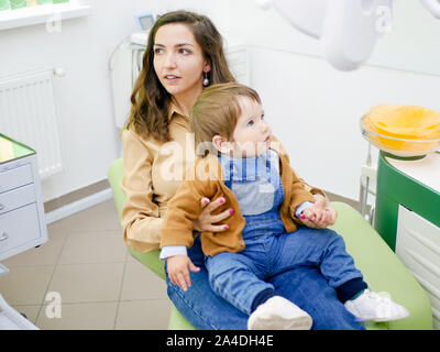 Baby sulle madri giro al dentisti appuntamento. Bambini il dentista. Foto Stock
