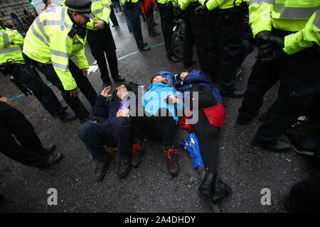 La polizia parla di manifestanti bloccando la strada al di fuori Mansion House nella città di Londra, durante una ribellione di estinzione (XR) cambiamenti climatici protesta. Foto Stock