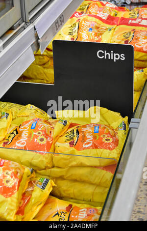 Close up di chip sign in alimenti congelati supermercato negozio self service display armadio con patatine imballaggi in plastica Borsa Londra Inghilterra REGNO UNITO Foto Stock