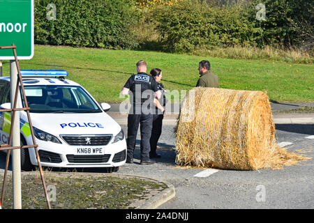 Poliziotto & poliziotta officer frequentare in pattuglia di polizia delle balle di paglia in incidente stradale A689 rotatoria Rushyford County Durham Regno Unito Inghilterra (vedere info) Foto Stock