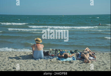 Turisti e residenti locali presso la spiaggia di San Marie de la Mer vicino alla regione della Camargue vicino a Arles nel sud della Francia Foto Stock