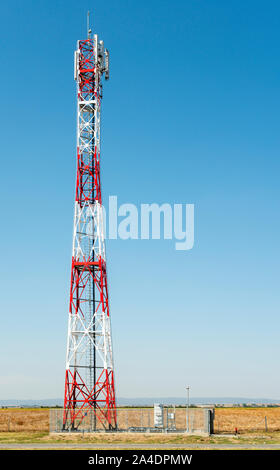 5G antenna per la connessione internet ad alta velocità di distribuzione. 5G di ripetitori fuori città. Colori luminosi rosso e bianco. Foto Stock
