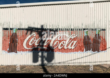 L'ombra di un palo telefonico gli accenti di un vecchio Coca-Cola segno su un edificio esterno Alpine, Texas Foto Stock