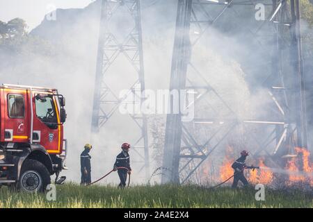 CCF 4000 e vigile del fuoco estinzione di un incendio a spazzola (ANCE) sotto alta tensione tralicci, i servizi di emergenza CENTRO DI CHAMBERY, LES MARCHE, SAVOY (73), Francia Foto Stock