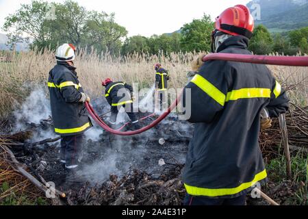 I VIGILI DEL FUOCO SPEGNERE UN INCENDIO a spazzola (ANCE) con le fruste di fuoco e di un tubo flessibile, i servizi di emergenza CENTRO DI CHAMBERY, LES MARCHE, SAVOY (73), Francia Foto Stock