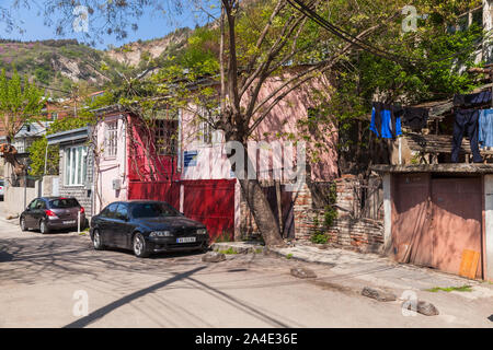 Tbilisi, Georgia - 28 Aprile 2019: Tbilisi street view con le auto parcheggiate vicino a vecchie case di vita Foto Stock