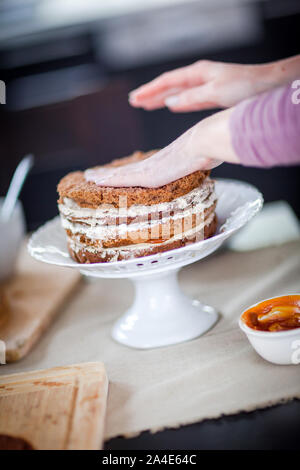 Creazione di una deliziosa multi-layered cake a casa Foto Stock