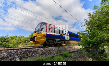 Nord del servizio ferroviario passeggeri che viaggiano in treno, cabina, binari ferroviari & cavi sovrastanti - Wharfedale linea nel West Yorkshire area metropolitana, Inghilterra, Regno Unito. Foto Stock