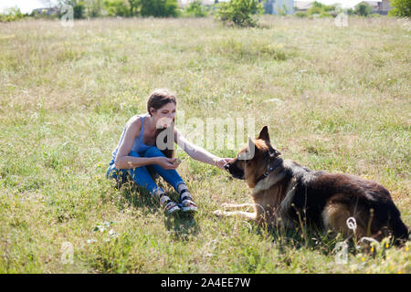 Treni donna pastore tedesco in park a piedi Foto Stock