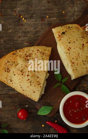 Calzone - Italiano CheesePizza ripiegato sul rustico sfondo di legno Foto Stock