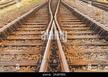 Due binari ferroviari si fondono insieme. Il vecchio nodo ferroviario con varie piste. Foto Stock