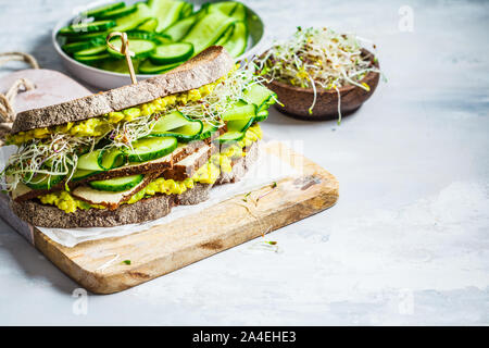 Verde grande panino con tofu, verdure, germogli e guacamole. Sano cibo vegan concetto. Foto Stock