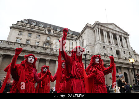 Il gruppo noto come i ribelli rosso si unisce a manifestanti bloccando la strada al di fuori Mansion House nella città di Londra, durante un XR il cambiamento climatico protesta. Foto Stock