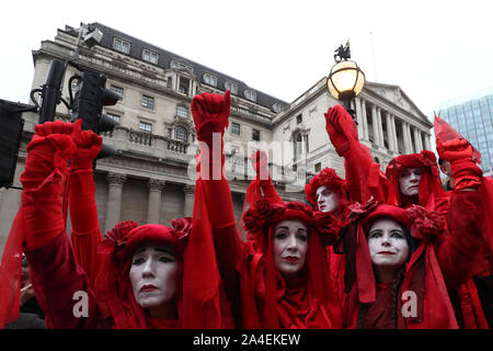 Il gruppo noto come i ribelli rosso si unisce a manifestanti bloccando la strada al di fuori Mansion House nella città di Londra, durante un XR il cambiamento climatico protesta. Foto Stock