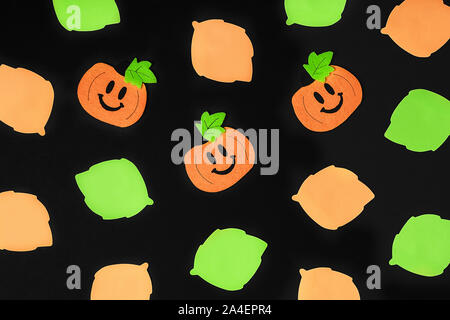 Sfondo di halloween decorazioni a tema. Toy zucche e assortimento di foglie su sfondo nero. Piatto stile di laici. Copia dello spazio. Copia dello spazio. Piatto s laici Foto Stock