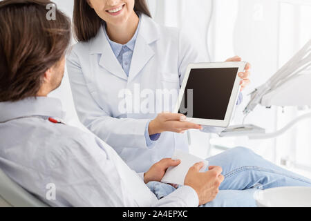 Chiusura del fustellato tavoletta digitale schermo azienda dal dentista Foto Stock