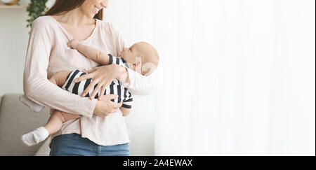 La mamma del tesoro del. Carino piccolo bambino in giovane donna con le mani in mano. Foto Stock