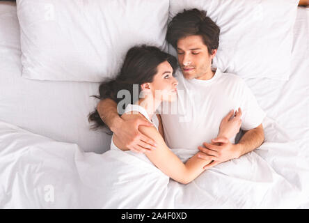 Giovani amare giovane dormire nel letto e abbracciando Foto Stock