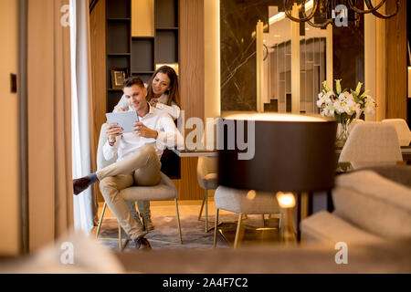 Bella coppia Giovane in un momento di relax a casa di lusso con tavoletta digitale Foto Stock