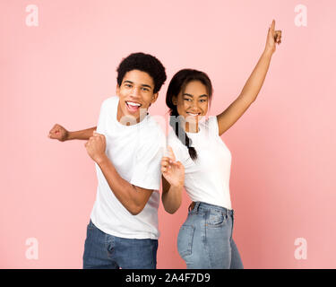 Sweet teen coppia danzante e ingannare, sfondo rosa Foto Stock