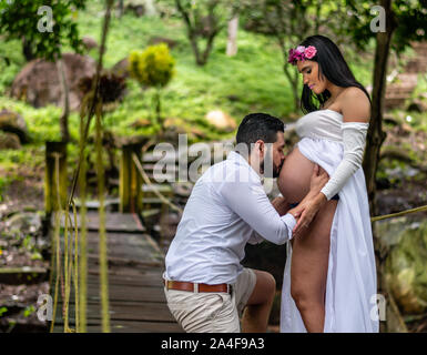 Ispanico marito baciare e azienda di sua moglie incinta pancia in Guatemala Foto Stock