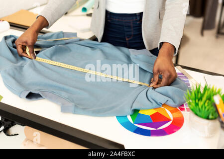 Irriconoscibile abbigliamento designer che lavora su un indumento In Atelier, ritagliato Foto Stock