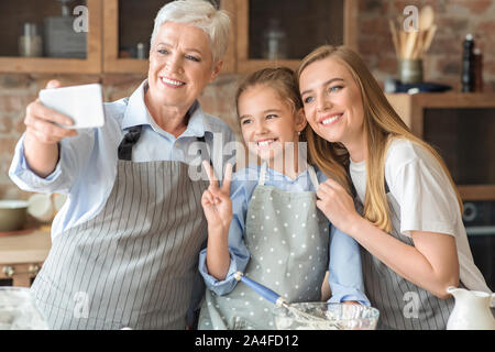 Gentile Famiglia femmina rendendo selfie sullo smartphone in cucina Foto Stock