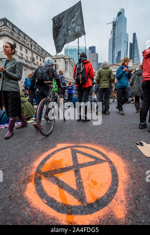 Londra, Regno Unito. Xiv oct, 2019. I manifestanti di spostarsi nel centro finanziario bloccando il bivio presso Banca - il sesto giorno della ribellione di estinzione ottobre azione che ha bloccato le strade del centro di Londra. Essi sono sottolineando nuovamente l'emergenza climatica, in una corsa contro il tempo per salvare il mondo da una catastrofe climatica. Questa è una parte del continuo ER e altre proteste di domanda di azione da parte del governo del Regno Unito sul clima di "crisi". L'azione è parte di un internazionale coordinato di protesta. Credito: Guy Bell/Alamy Live News Foto Stock