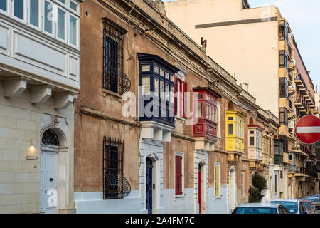 Casa residenziale con facciata tradizionale maltese variopinti balconi in legno a Sliema Malta, nella luce del sole serale. Autentica Maltese scena urbana. Foto Stock