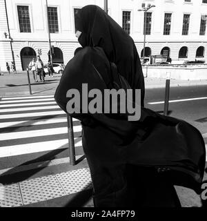 La donna musulmana che indossa chador completo sorge in una strada di Lione, Francia Foto Stock