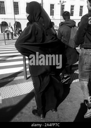 La donna musulmana che indossa chador completo sorge in una strada di Lione, Francia Foto Stock