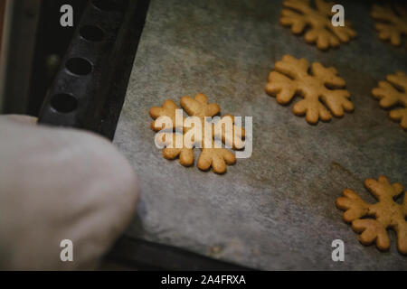 Per ottenere gingerbread cookie sotto forma di fiocchi di neve da una presina. Foto Stock