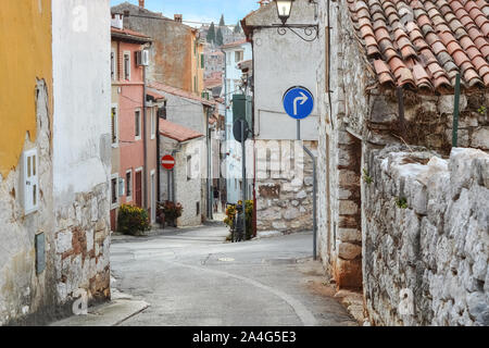 Andando giù per una strada di avvolgimento della parte vecchia di Rovinj in Croazia, con vecchie case di pietra. Foto Stock